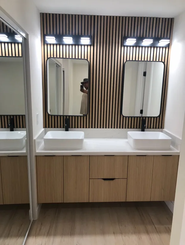 Finished bathroom remodel with floating double vanity, vessel sinks and wood slat accent wall